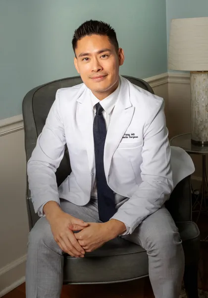 Dr. Albert Yang, medical director of River City Aesthetics, seated in a white coat
