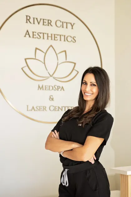 Jessica Stites, licensed esthetician and facial specialist, in front of the River City Aesthetics studio wall